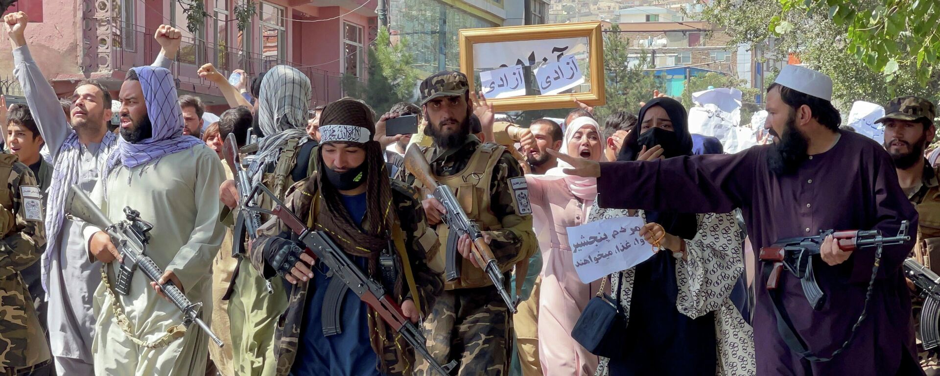 Afganistan başkenti Kabil'de Pakistan karşıtı sloganlar atan kadın erkek karışık protestocuların önüne set çekmeye çalışan silahlı Taliban militanları - Sputnik Türkiye, 1920, 20.12.2022