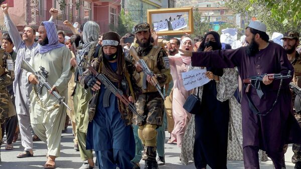 Afganistan başkenti Kabil'de Pakistan karşıtı sloganlar atan kadın erkek karışık protestocuların önüne set çekmeye çalışan silahlı Taliban militanları - Sputnik Türkiye