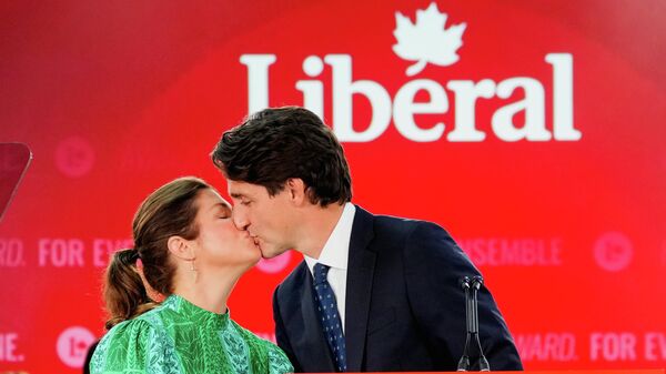 Kanada baskın seçimlerinin ilk sonuçlarının ardından açıklama yapan Liberal Partili Başbakan Justin Trudeau, kürsüde Sophie Gregoire ile öpüşürken - Sputnik Türkiye