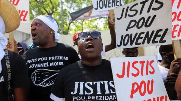 ABD destekli darbeyle öldürülen Haiti Devlet Başkanı Jovenel Moise suikastıyla ilgili davanın görüldüğü başkent Port-au-Prince'deki mahkeme önünde 'Jovenel için adalet' pankartları açan göstericiler  - Sputnik Türkiye