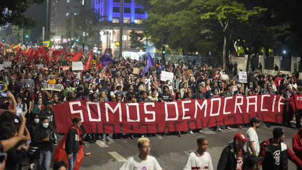 Brezilya'nın Sao Paulo şehrinde Portekizce Biz Demokrasiyiz yazılı pankart açarak yürüyen göstericiler, 8 Ocak 2023'te devlet başkanlığı, Kongre ve Yüksek Mahkeme'yi basarak darbe girişiminde bulunan önceki Devlet Başkanı Jair Bolsonaro'nun taraftarlarının yargılanıp hapse atılmasını ve demokrasinin korunmasını talep etti.  - Sputnik Türkiye