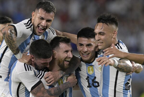 Arjantinli futbolcular, başlama vuruşundan önce Dünya Kupası&#x27;nın önünde fotoğraf çektirirken, Messi, teknik direktör Lionel Scaloni ve diğer oyuncular ailelerini stada getirdi. - Sputnik Türkiye