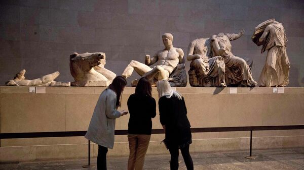 Women look at a statue of the Greek god Dionysus, part of the Parthenon Marbles - Sputnik Türkiye