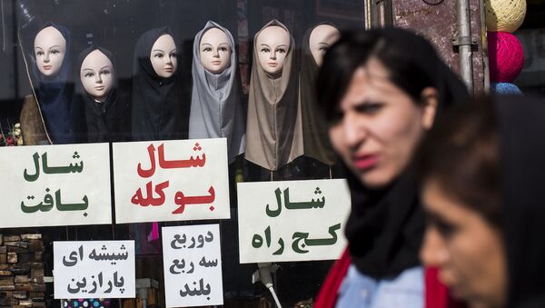 İran'da eşarp satan bir dükkanın önünden geçen kadınlar. - Sputnik Türkiye