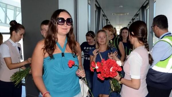 Türkiye-Rusya arasındaki sorunların çözüme kavuşturulmasının ardından Milas-Bodrum Havalimanı'na gelen 200 kişilik ilk Rus turist kafilesi karanfillerle karşılandı. - Sputnik Türkiye