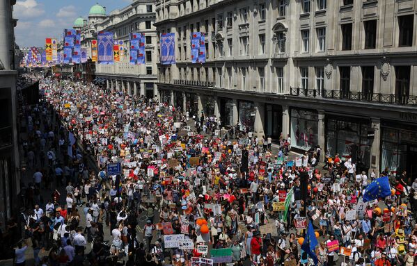 Trump'ın İngltere ziyareti Londra'da çoğunluğunu kadınların oluşturduğu on binlerce kişi tarafından protesto ediliyor. Bir festival havasında geçen prostesto gösterisine katılanlar ABD Başkanı'nı ırkçılık, kadın düşmanlığı ve işkenceyle suçlayan pankartlar taşıyor.  Portland Place'ten başlayıp Oxford Circus yönünde devam eden protestolara katılanlar yanlarında getirdikleri tencere, tava, düdük ve davullarla ses çıkartıyor - Sputnik Türkiye