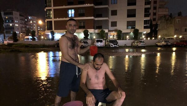 İzmir'de su kesintisine dikkati çekmek için yağmur suyuyla sokakta yıkandılar - Sputnik Türkiye