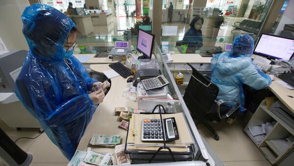 Koronavirüs salgınıyla mücadele eden Çin'de banka memurları koruyucu kıyafetler giyerek çalışıyor ve para sayıyor. - Sputnik Türkiye