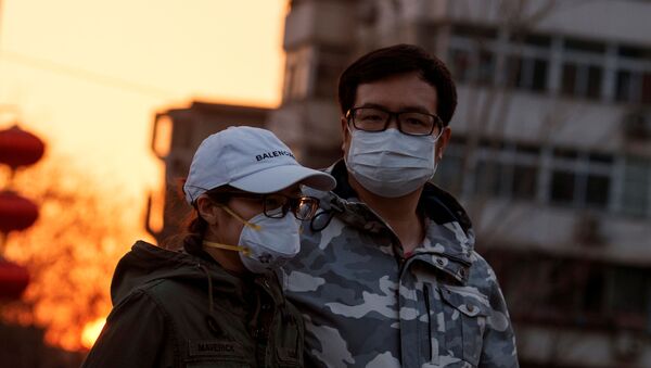 Çin başkenti Pekin'de koronavirüs önlemi olarak maskeyle dolaşan bir çift - Sputnik Türkiye